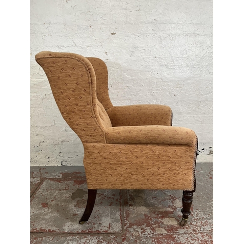 161 - A late 19th/early 20th century mahogany and fabric upholstered wing back armchair