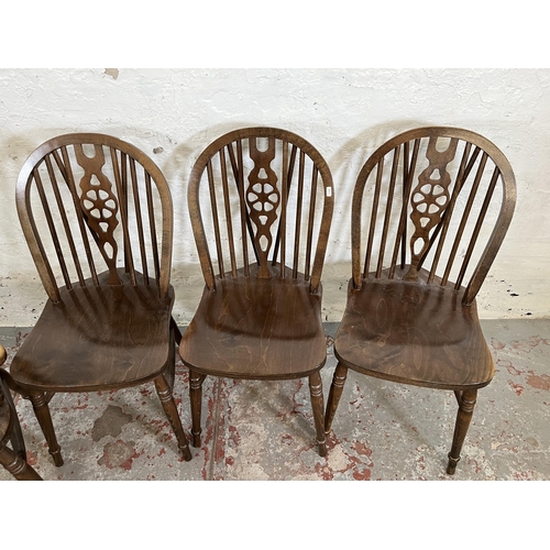 173 - Four beech wheelback dining chairs