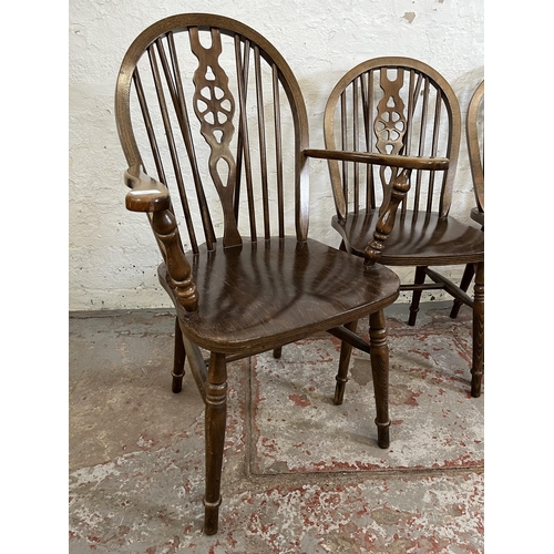 173 - Four beech wheelback dining chairs