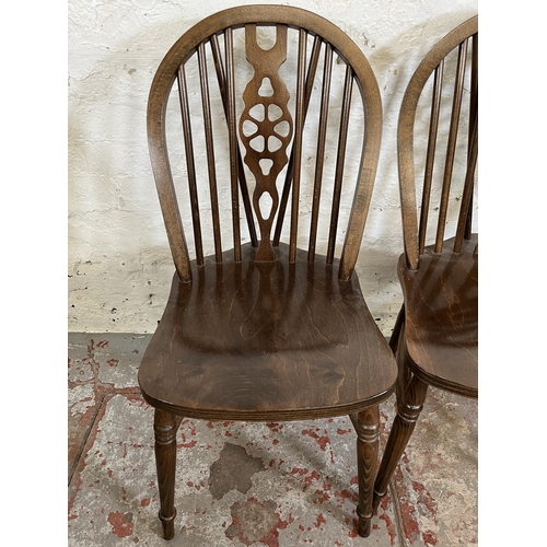 173 - Four beech wheelback dining chairs