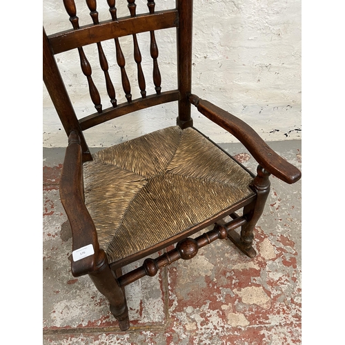 176 - A late 18th century elm and beech spindle back rocking chair with rush seat