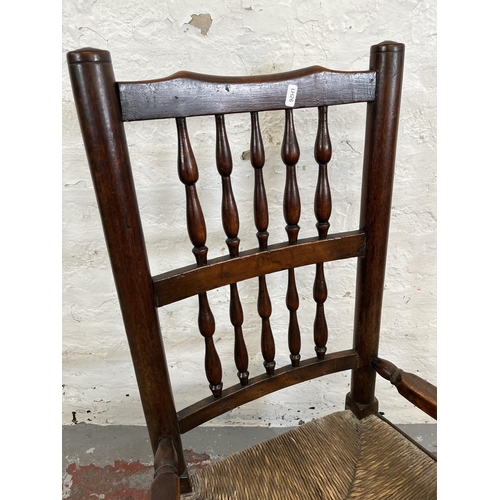 176 - A late 18th century elm and beech spindle back rocking chair with rush seat