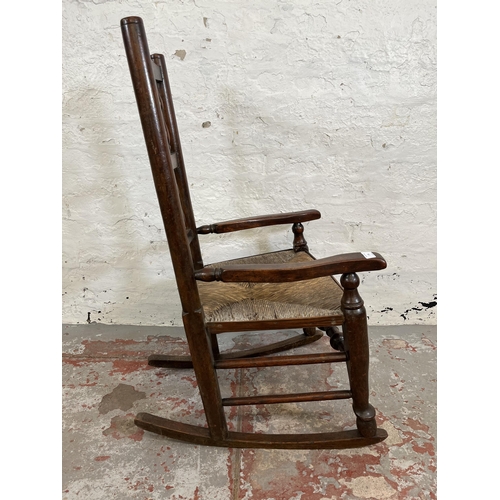 176 - A late 18th century elm and beech spindle back rocking chair with rush seat