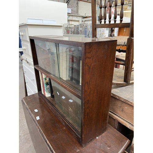 186 - A mid 20th century oak two tier bookcase with four glass sliding doors and books