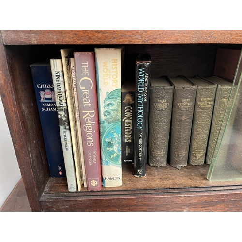 186 - A mid 20th century oak two tier bookcase with four glass sliding doors and books