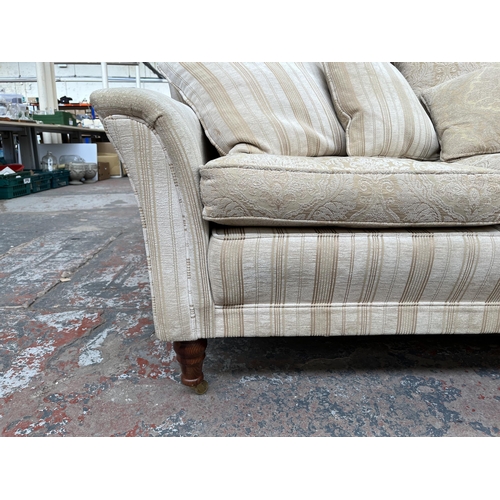 200 - Two Greensmith Stowe fabric upholstered low arm two seater sofas with mahogany supports and brass ca... 