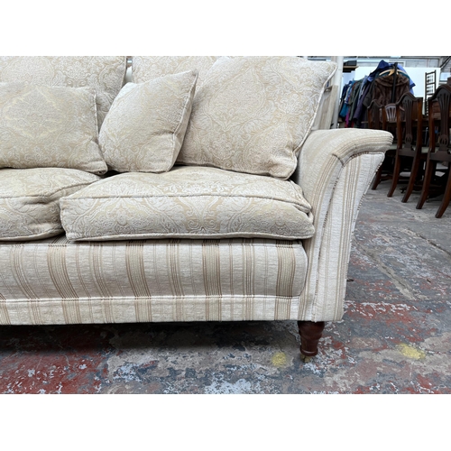 200 - Two Greensmith Stowe fabric upholstered low arm two seater sofas with mahogany supports and brass ca... 