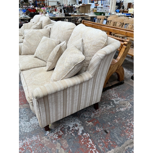 200 - Two Greensmith Stowe fabric upholstered low arm two seater sofas with mahogany supports and brass ca... 