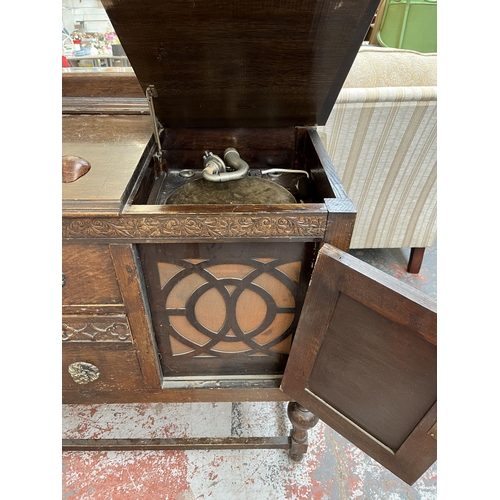 208 - A 1920s/30s carved oak mirror back sideboard with baluster supports and fitted gramophone