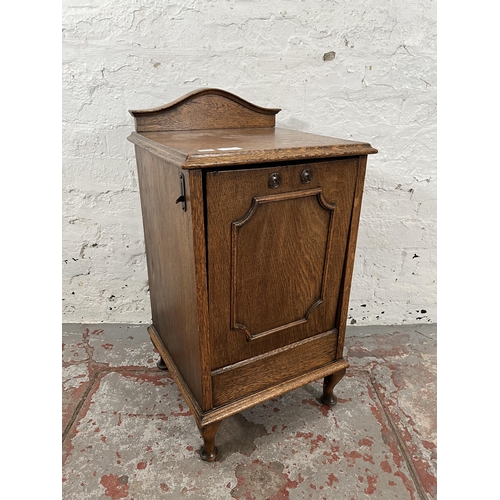 61 - An Edwardian oak purdonium with moulded fall front door and cabriole supports