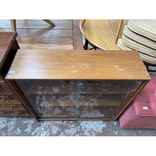 65 - A Turnidge of London Ltd. teak bookcase with two glass sliding doors