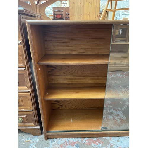 65 - A Turnidge of London Ltd. teak bookcase with two glass sliding doors