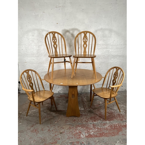 79 - An Ercol Windsor blonde elm drop leaf gate leg dining table and four Ercol blonde elm Fleur De Lys d... 