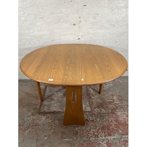 79 - An Ercol Windsor blonde elm drop leaf gate leg dining table and four Ercol blonde elm Fleur De Lys d... 