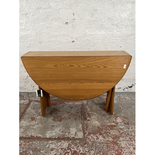 79 - An Ercol Windsor blonde elm drop leaf gate leg dining table and four Ercol blonde elm Fleur De Lys d... 