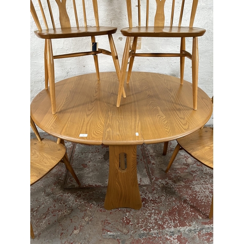 79 - An Ercol Windsor blonde elm drop leaf gate leg dining table and four Ercol blonde elm Fleur De Lys d... 