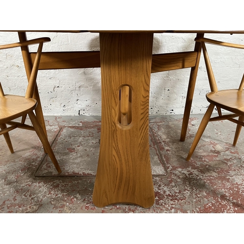 79 - An Ercol Windsor blonde elm drop leaf gate leg dining table and four Ercol blonde elm Fleur De Lys d... 