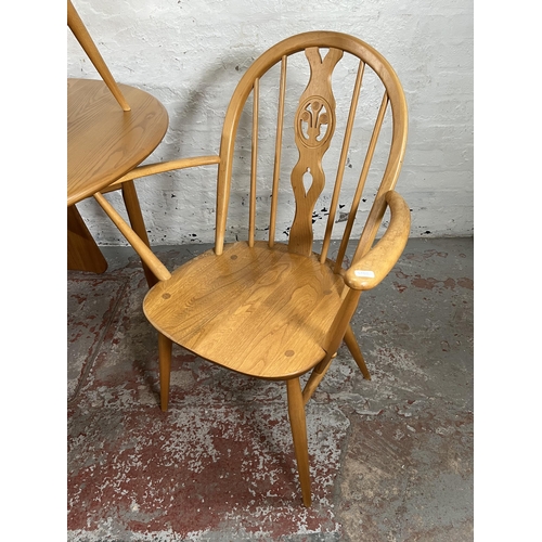 79 - An Ercol Windsor blonde elm drop leaf gate leg dining table and four Ercol blonde elm Fleur De Lys d... 