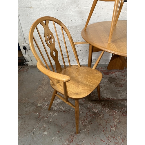 79 - An Ercol Windsor blonde elm drop leaf gate leg dining table and four Ercol blonde elm Fleur De Lys d... 