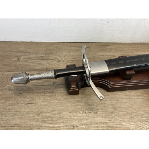 501 - A presentation sword with black leather scabbard on oak stand - presented to Amanda Kate Harris for ... 