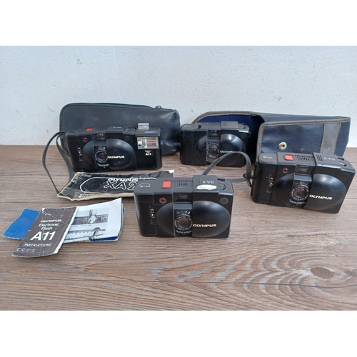 601 - Four Olympus compact clam-shell cameras, one cased XA2 fitted with A11 flash with instruction manual... 