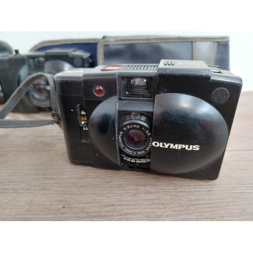 601 - Four Olympus compact clam-shell cameras, one cased XA2 fitted with A11 flash with instruction manual... 