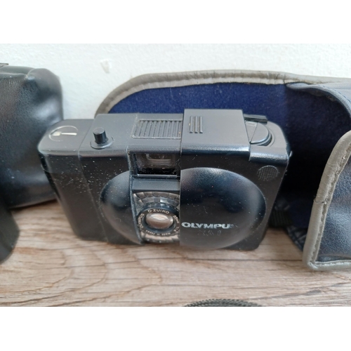 601 - Four Olympus compact clam-shell cameras, one cased XA2 fitted with A11 flash with instruction manual... 