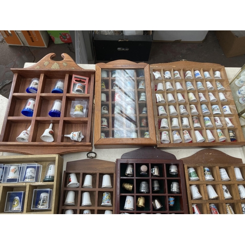 317 - A large collection of thimbles and display racks to include ceramic, hallmarked sterling silver, gla... 