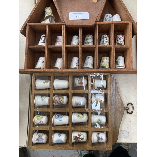 317 - A large collection of thimbles and display racks to include ceramic, hallmarked sterling silver, gla... 