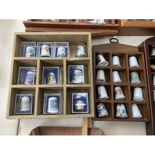 317 - A large collection of thimbles and display racks to include ceramic, hallmarked sterling silver, gla... 