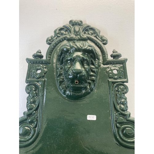 338 - A Victorian style green painted cast metal wall fountain with lion face design  - approx. 76cm high