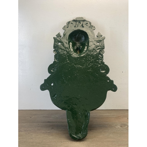 338 - A Victorian style green painted cast metal wall fountain with lion face design  - approx. 76cm high