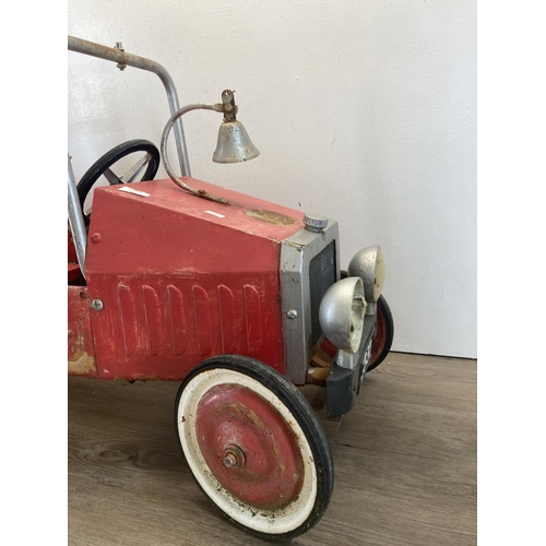 365 - A mid 20th century red painted metal ride on pedal fire truck - approx. 54cm high x 40cm wide x 97cm... 