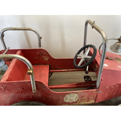 365 - A mid 20th century red painted metal ride on pedal fire truck - approx. 54cm high x 40cm wide x 97cm... 