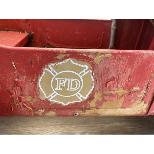 365 - A mid 20th century red painted metal ride on pedal fire truck - approx. 54cm high x 40cm wide x 97cm... 