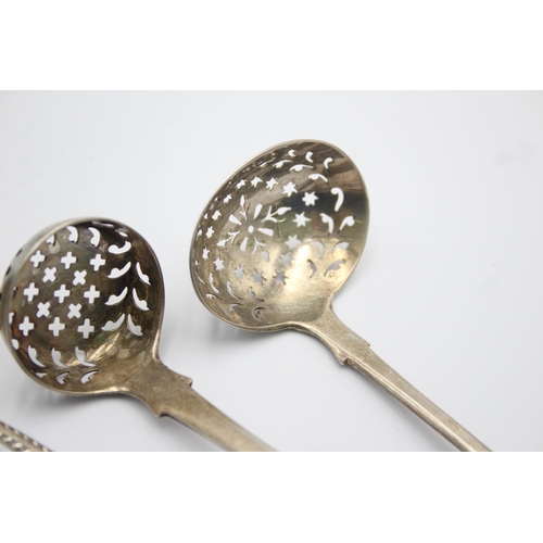 1300 - Three pieces of antique hallmarked sterling silver, two sugar sifters and one ladle - approx. gross ... 