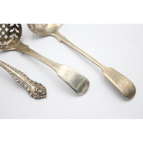 1300 - Three pieces of antique hallmarked sterling silver, two sugar sifters and one ladle - approx. gross ... 