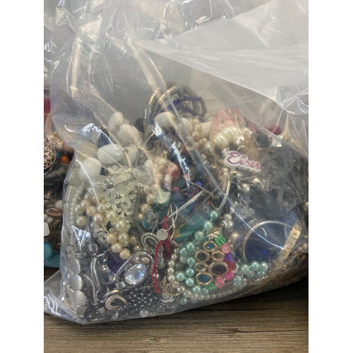 415 - Four bags containing a large quantity of costume jewellery