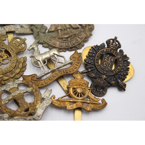 1394 - Ten military cap badges to include Royal Marines, Irish, Royal Warwickshire etc.