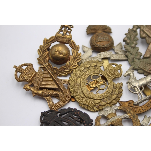 1394 - Ten military cap badges to include Royal Marines, Irish, Royal Warwickshire etc.