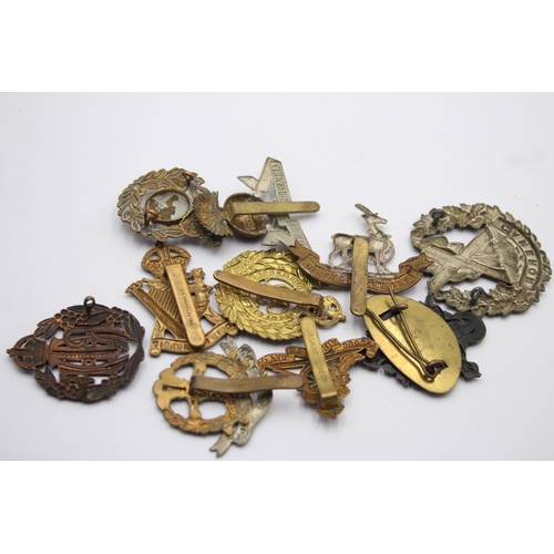 1394 - Ten military cap badges to include Royal Marines, Irish, Royal Warwickshire etc.