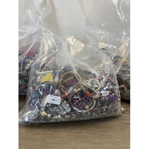 409 - Three bags containing a large quantity of costume jewellery