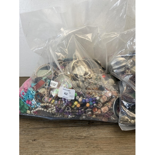 412 - Four bags containing a large quantity of costume jewellery