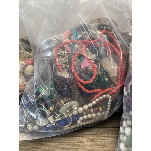 412 - Four bags containing a large quantity of costume jewellery