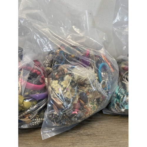 413 - Four bags containing a large quantity of costume jewellery