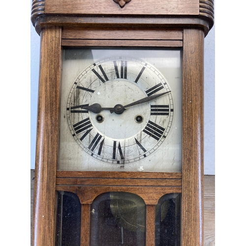 495 - An oak cased chiming wall clock with pendulum and key - approx. 61cm high