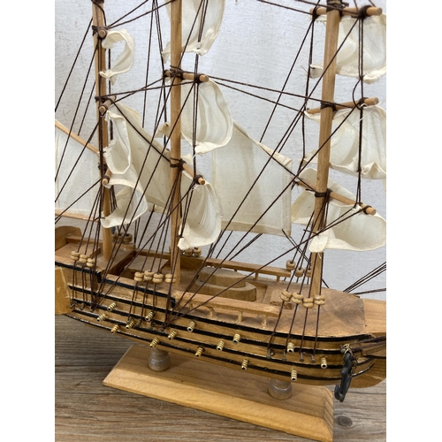 506 - Three wooden model ships to include Cutty Sark, HMS Bounty etc. - largest approx. 33cm high