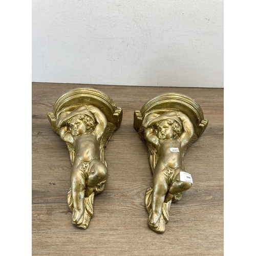 508 - A pair of gilded cast stone cherub wall brackets - approx. 30cm high