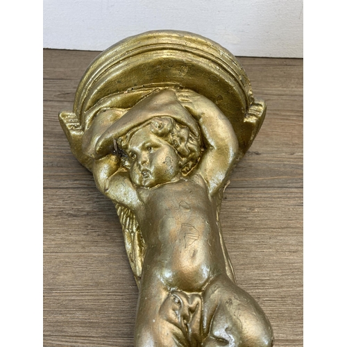 508 - A pair of gilded cast stone cherub wall brackets - approx. 30cm high