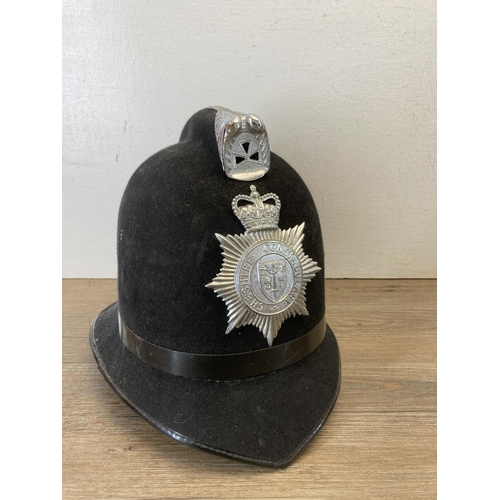 540 - Three police helmets and caps, two with Cheshire Constabulary badges